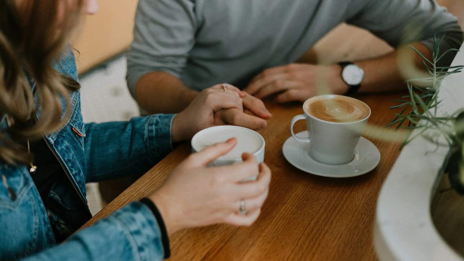 Couple holding hands over coffee representing online dating investigation and relationship verification services